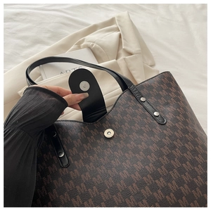 Detail of brown monogram tote bag showing magnetic clasp closure and luxury pebble texture