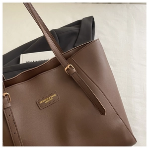 Détail d'un cabas en cuir marron avec boucle dorée et texture de haute qualité raffinée
