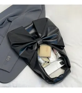 Détail du sac à main noir à nœud révélant un grand espace pour les objets quotidiens