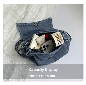 Detailed interior view of a large denim crossbody bag with chain strap and essentials