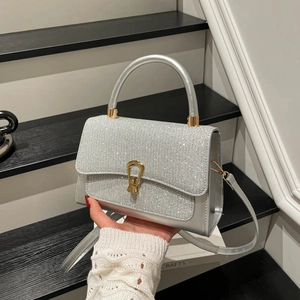 Elegant silver rhinestone crossbody bag with a horseshoe clasp and top handle