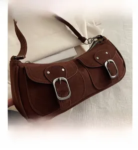 Detail shot of vintage dark brown suede baguette bag featuring front double buckle pockets