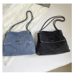 Flat lay of denim chain bags in blue and black with metal buckle on white lace