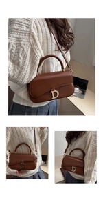 Sac bandoulière en cuir marron avec boucle D dorée, porté par un mannequin