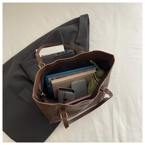 Vue macro montrant l'intérieur spacieux de ce grand sac cabas en cuir marron avec accessoires