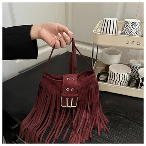 Détail du sac à bandoulière bordeaux à franges avec boucle et œillets métalliques