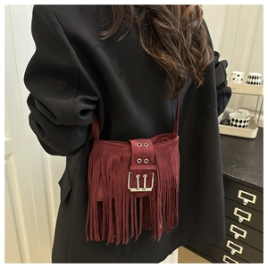 Détail du sac bandoulière en daim bordeaux avec longues franges et boucles en métal