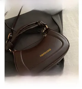 Top view detail of coffee brown PU leather shoulder bag with golden zipper and logo