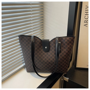 Detail of dark brown tote bag with M-pattern print on a minimalist window background