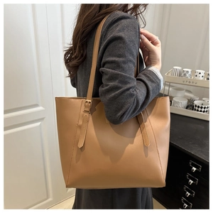 Détail de la boucle réglable sur un grand sac cabas en simili cuir marron clair