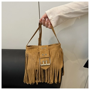 Détail du sac à main bohème en daim camel avec franges et boucle décorative en métal