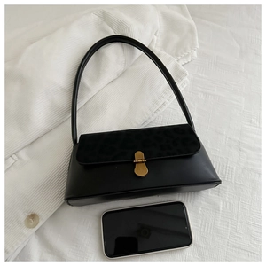 Detail view of black baguette bag showing size reference with a smartphone next to it