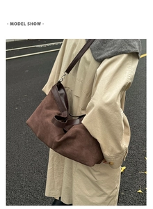 Brown suede tote bag worn with a beige trench coat against an autumn street background