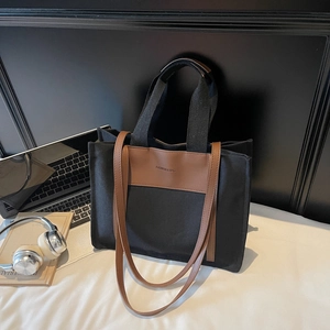 Large canvas tote bag in black and brown with dual straps for daily commuting