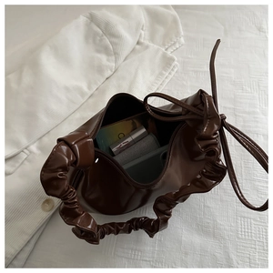 Detail view of the deep brown cloud bag interior and soft scrunchie handle design