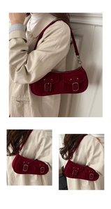 Dettaglio borsa baguette in pelle scamosciata rosso scuro con tasche cargo e fibbie