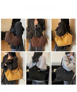 Détail du sac cabas en suède avec bandoulière en cuir et boucle dorée en divers tons