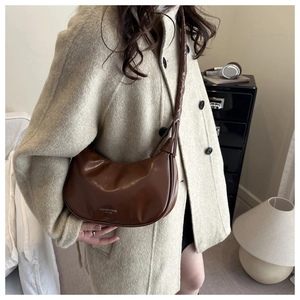 Sac hobo en cuir marron avec silhouette en croissant porté par un mannequin