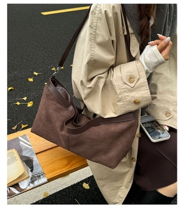 Close-up of a dark brown suede tote bag featuring premium leather stitching and texture