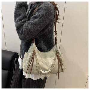 Detail of the minimalist grey tote bag with pearl chain and metallic zipper tassels