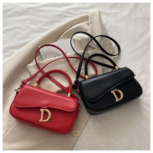 Détail de sacs à main rouges et noirs avec une boucle emblématique en métal doré en D