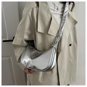 Close-up of metallic silver hobo bag with fashion engraving and wide shoulder strap