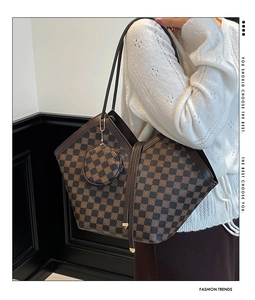 Detail of checkered shoulder tote bag with matching round pouch pendant on model
