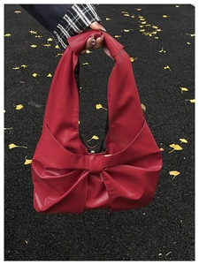 Détail du sac à main rouge avec nœud en cuir PU mat et fermoir magnétique