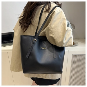 Détail d'un grand sac fourre-tout en cuir noir avec boucle dorée et bandoulière réglable