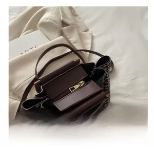 Detail view of smooth golden zipper and plaid fabric texture inside the shoulder bag
