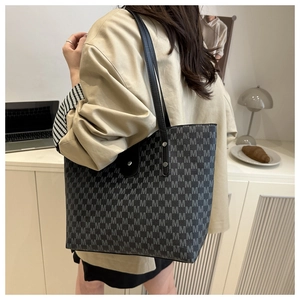 Detail of the high-capacity tote bag with M-pattern texture and rivet reinforced handle