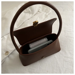 Brown vintage baguette bag interior showing capacity for smartphone and wallet