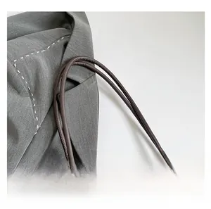 Detail of classic brown checkered pattern and durable leather handle on tote bag