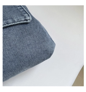 Detail shot of navy blue denim tote bag texture with precise stitching and fabric grain