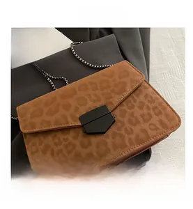 Détail d'un sac bandoulière léopard avec texture mate et fermoir métallique chic