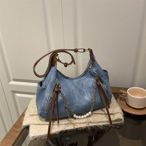 Blue denim hobo bag with pearl chain decoration and brown handles on knit scarf