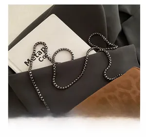 Détail du sac léopard avec bandoulière en chaîne gris métal et accessoires élégants