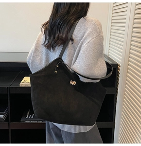 Close-up of the vintage black suede tote bag with elegant golden twist-lock buckle