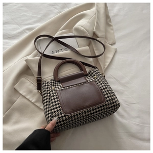 Flat lay of retro houndstooth shoulder bag with brown leather details and top handle