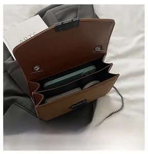 Détail des compartiments de ce sac bandoulière marron avec sa chaîne métallique