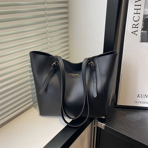 Sac fourre-tout minimaliste en cuir noir avec fines bandoulières et logo de mode