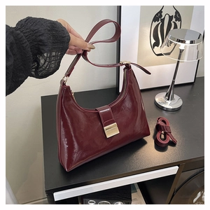 Detail of wine red hobo bag in glossy oil wax leather with adjustable dual straps
