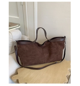 Detailed close-up of dark brown matte suede tote bag on a stylish wooden stool