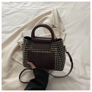 Detail view of houndstress fabric and brown leather stitching on vintage crossbody bag