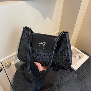 Black leather underarm bag with crocodile pattern texture and silver bow buckle detail