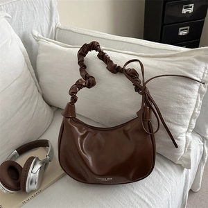 Deep brown crescent shoulder bag with pleated handle and side ribbon details