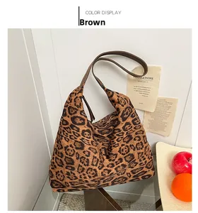 Détail du sac cabas imprimé léopard avec bandoulière en cuir brun et texture en daim