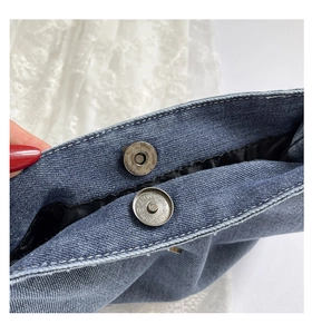 Detailed macro view of magnetic clasp and denim texture on large tote bag