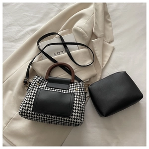 Detail of houndstooth handbag with wooden handle and matching black leather pouch