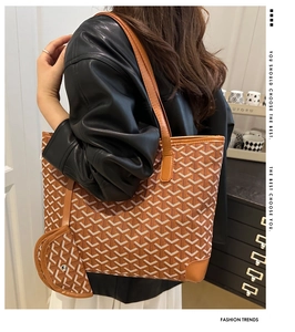 Model wearing large tote bag with classic woven pattern and matching pouch on shoulder